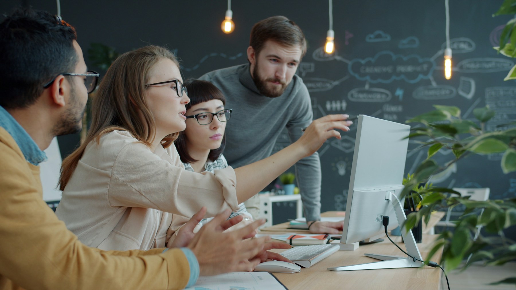 Software developers collaborating around a computer