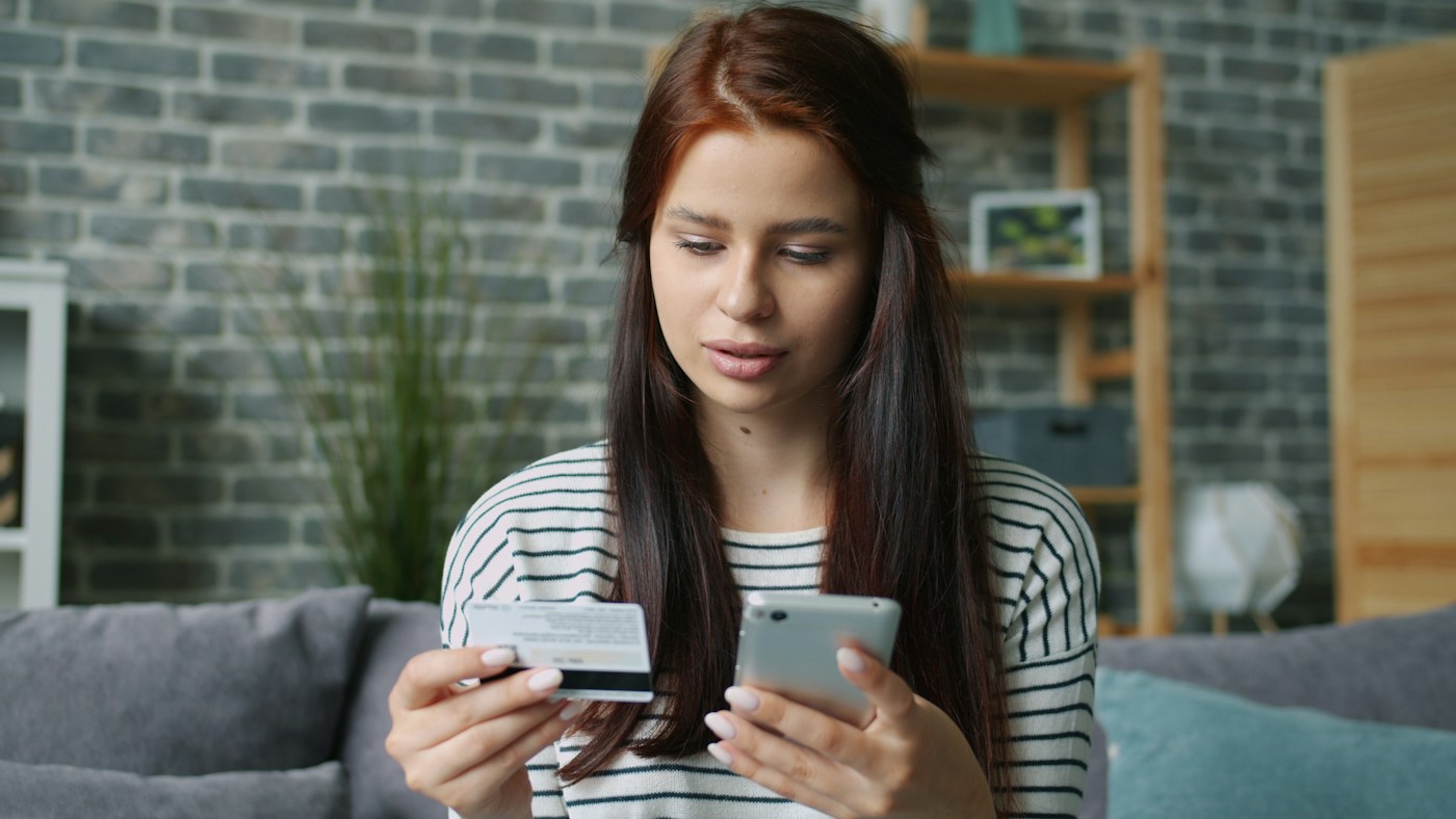 A customer shopping online with a phone and payment card